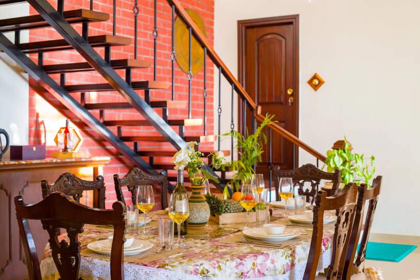Dining table set for a meal beside the staircase
